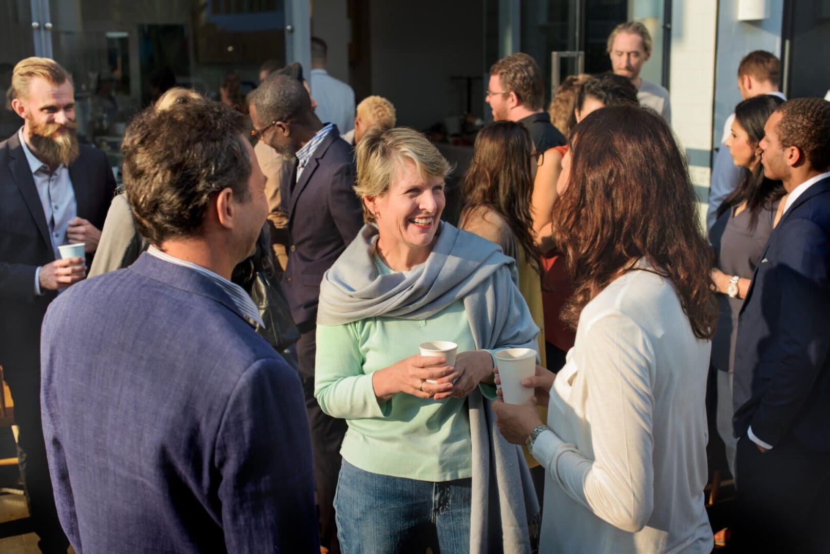 Group of people socializing with coffee cups.