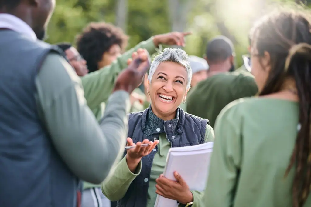 Woman laughing with friends outdoors.