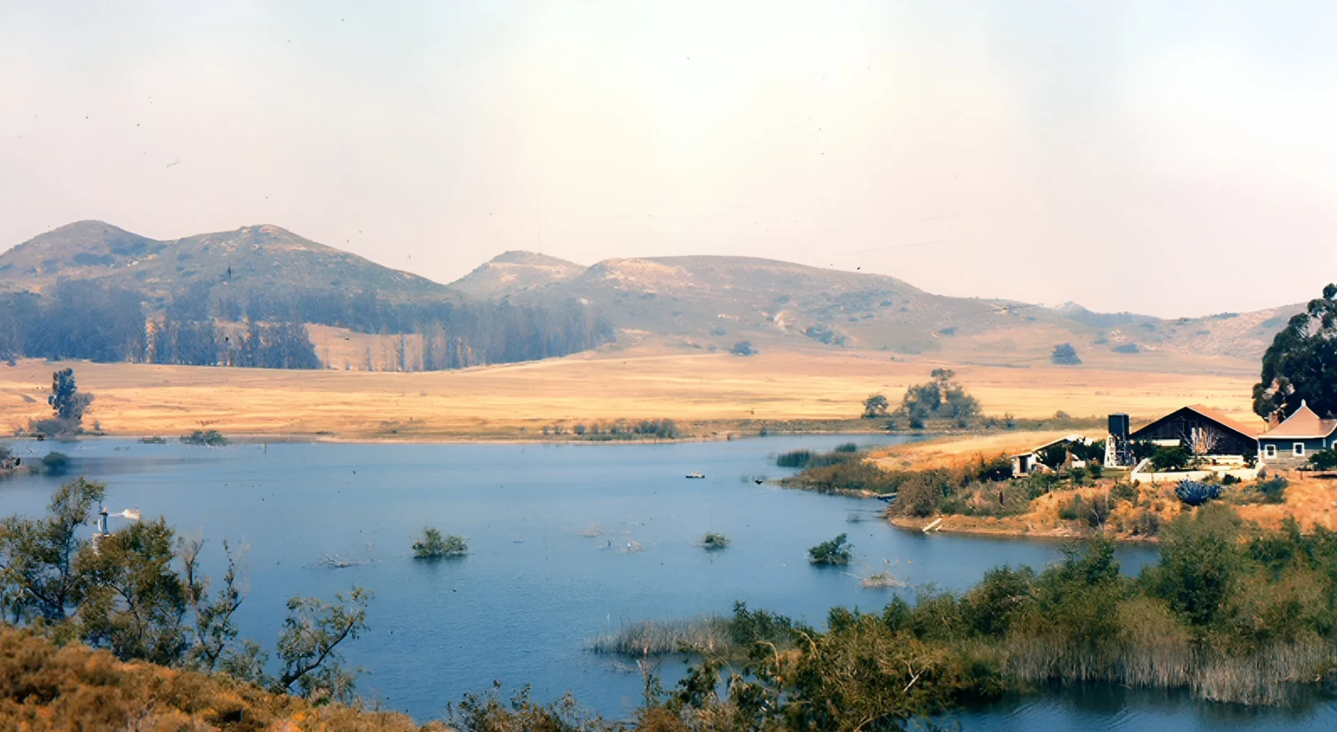 A lake surrounded by hills and trees.