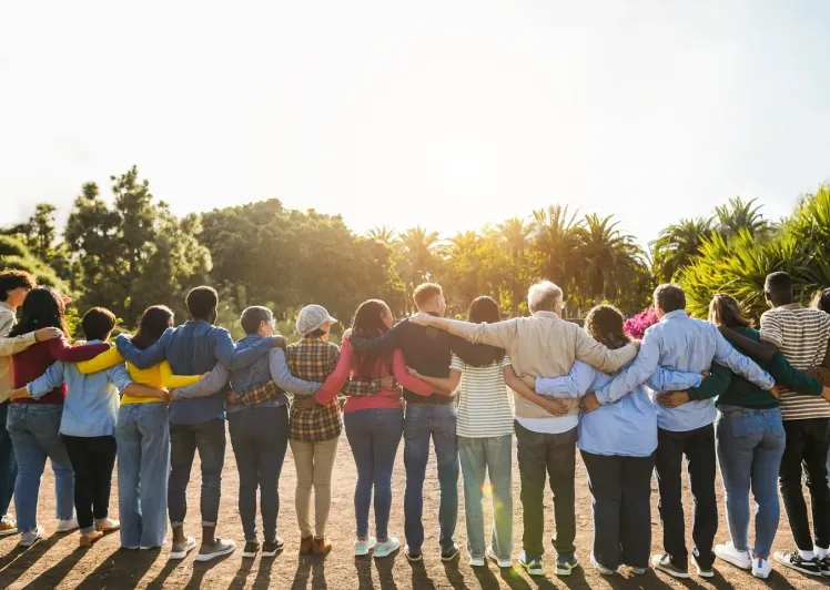 Group of people hugging in a park.